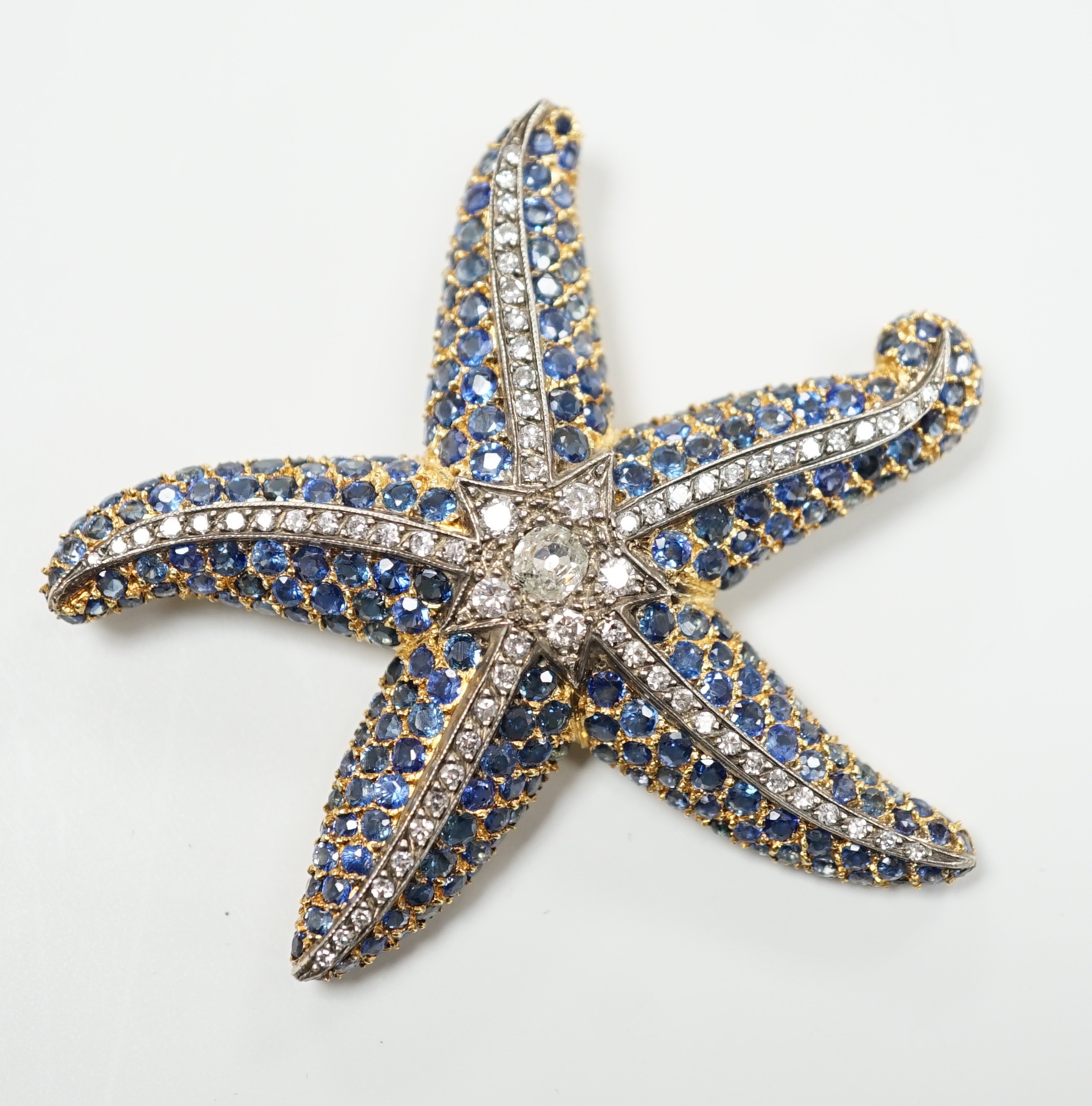 A mid to late 20th century 750 yellow metal, sapphire and diamond cluster set starfish brooch, maker, PA AP? 54mm, gross weight 19.3 grams, central stone diameter 4.4mm.